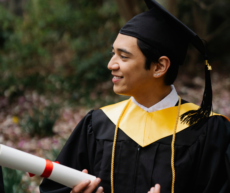 smiling man in academic dress holding diploma