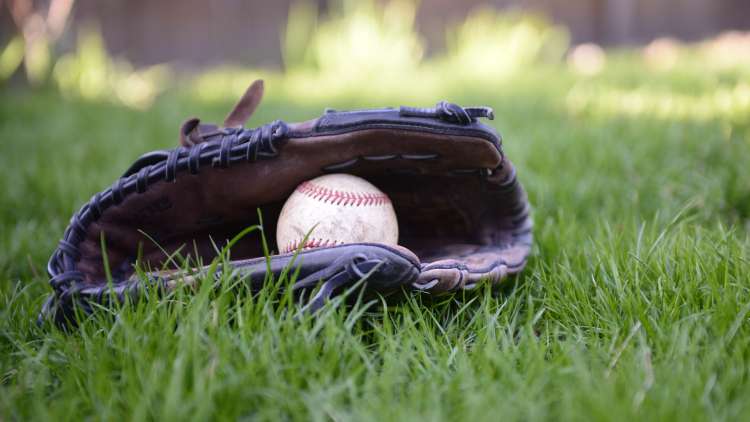 Gant et balle de baseball dans l'herbe